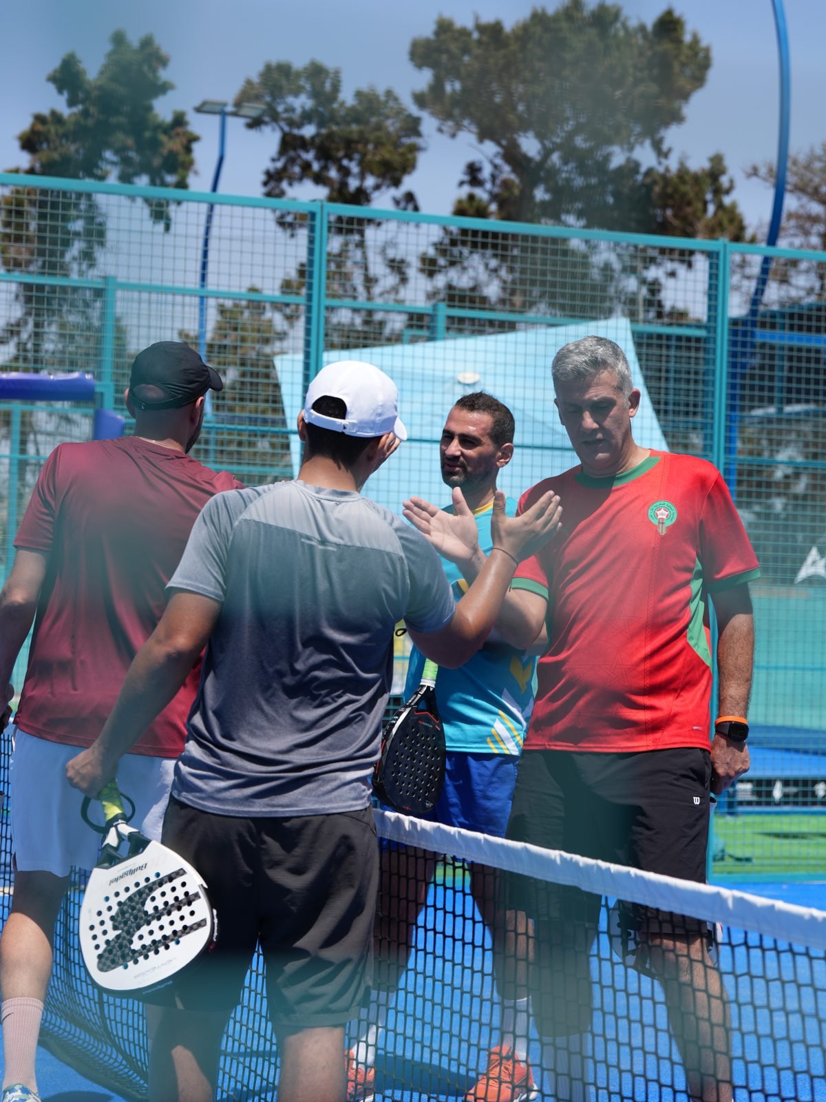 Poignée de main après un match de padel entre entreprises