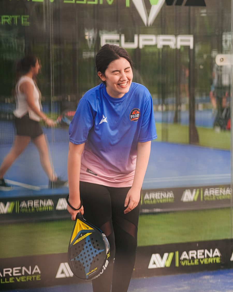 Une joueuse rit pendant une initiation au padel